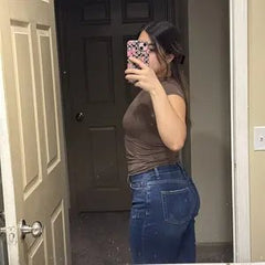 Customer wearing light-wash Sculpt Jeans in a hallway mirror